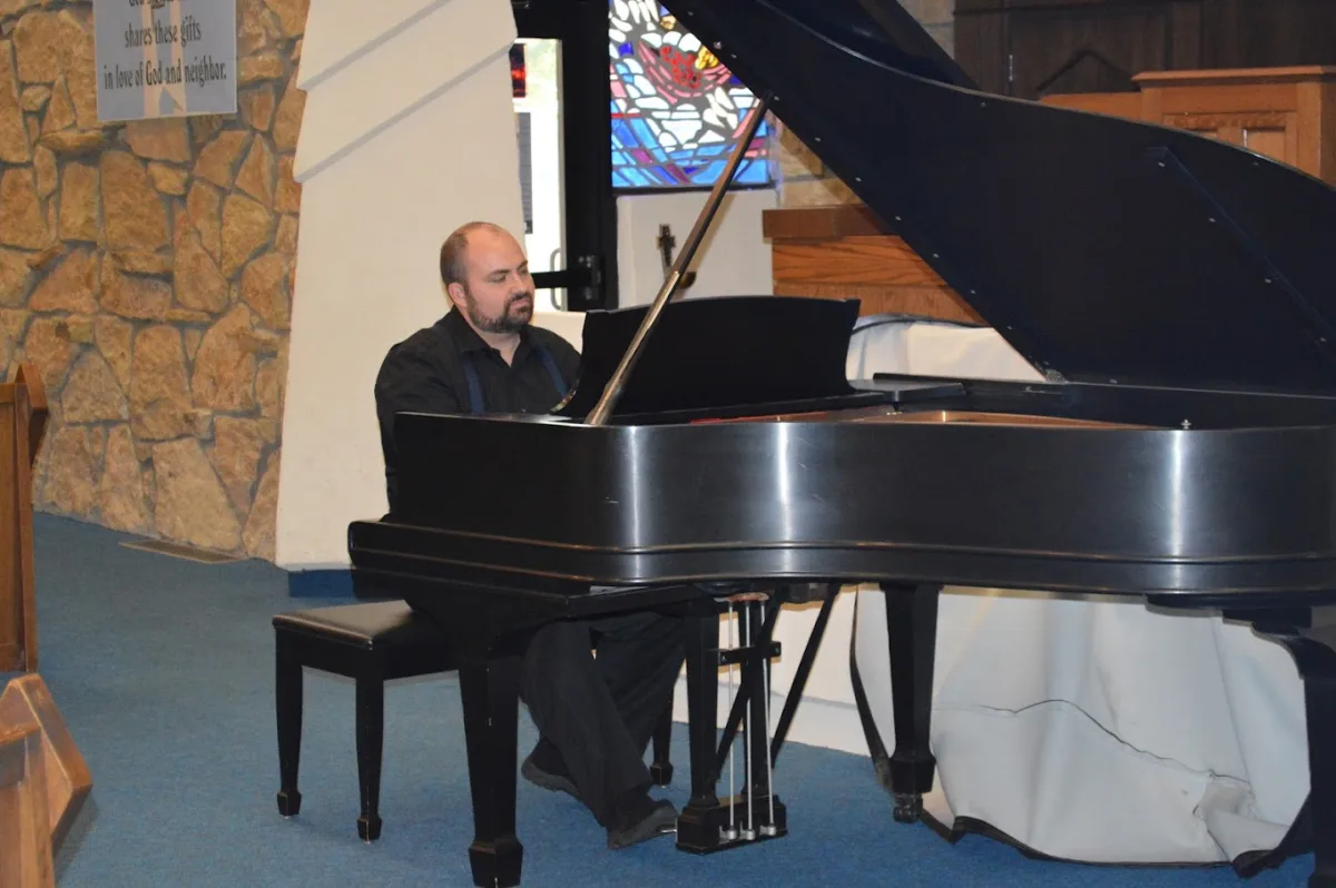 Cody Handlin at a grand piano in a church sanctuary